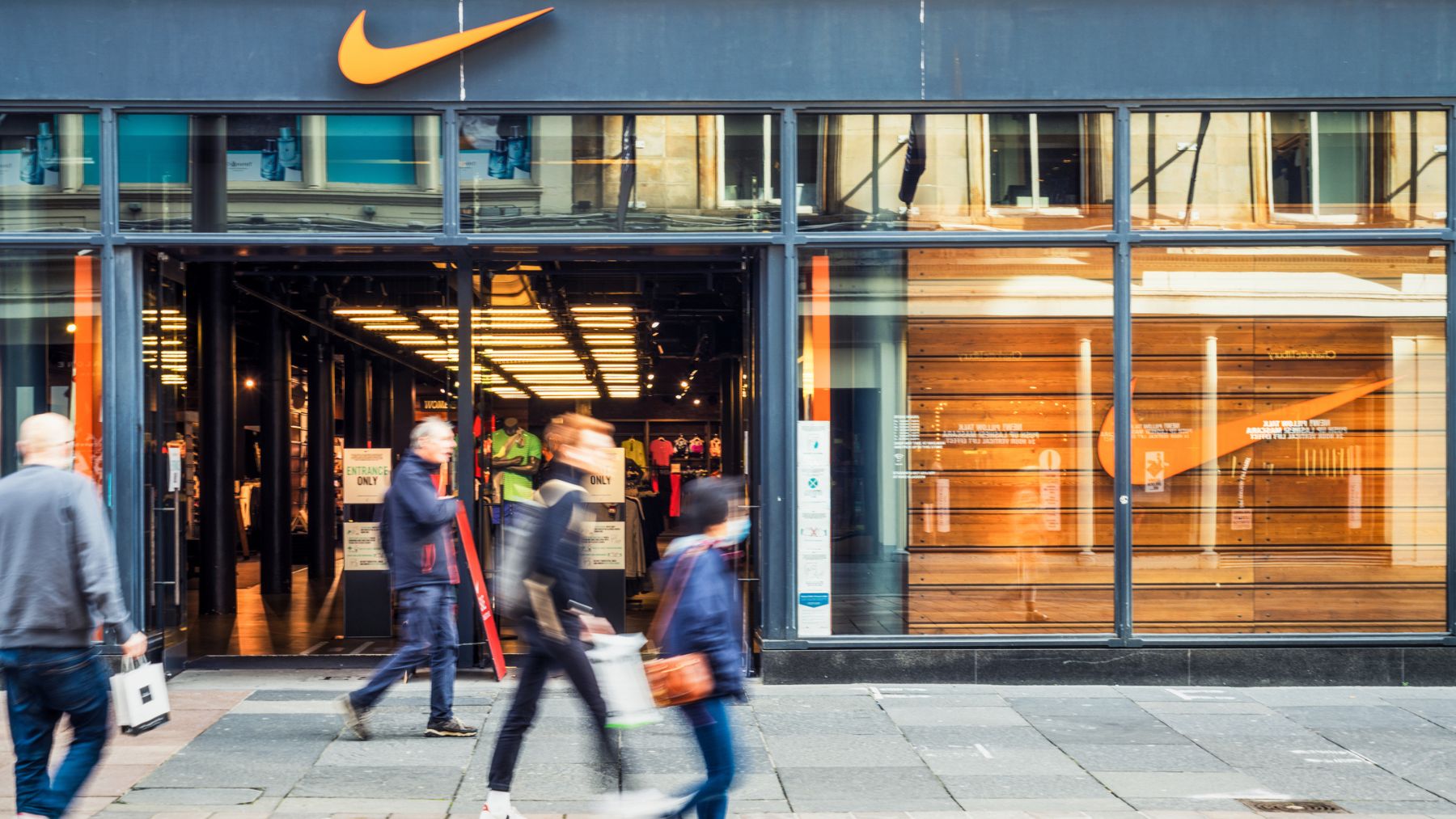 Varias personas caminando por una tienda Nike