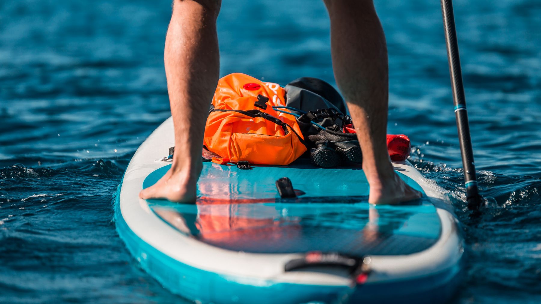 Un hombre sobre una tabla de paddle surf.