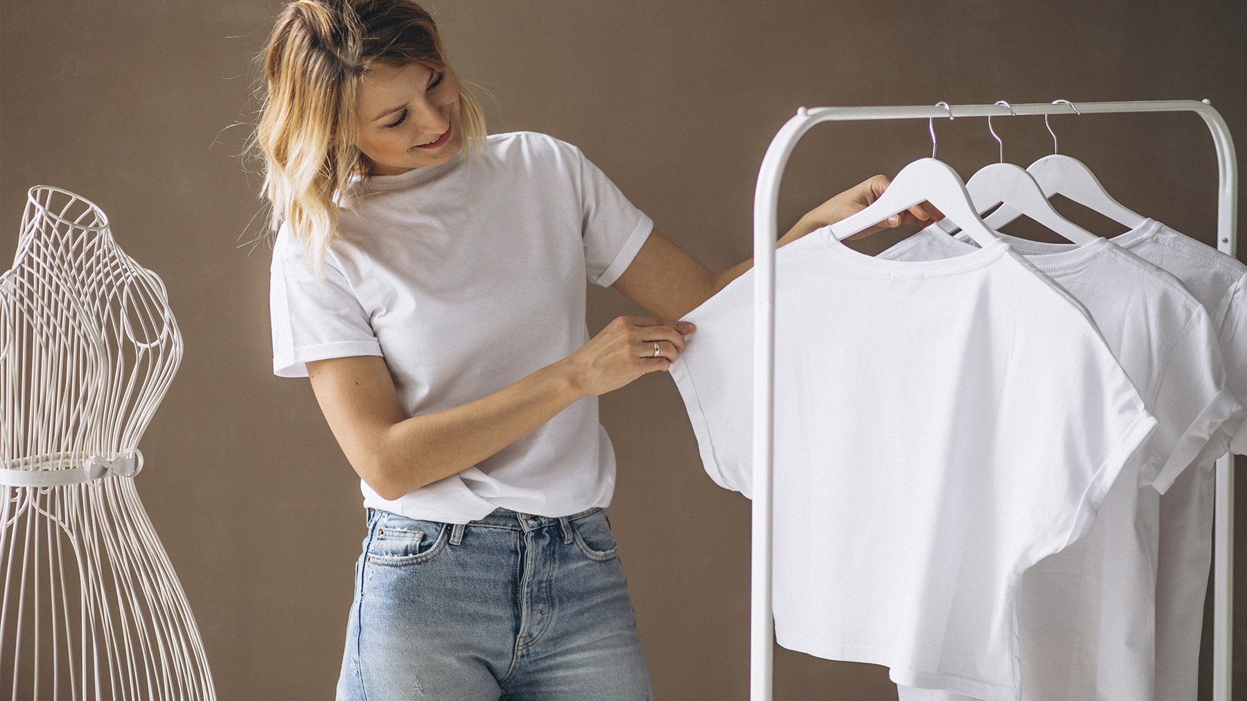Mujer viendo sus prendas blancas. Foto: Freepik.
