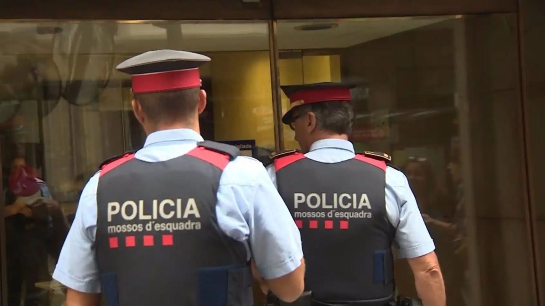 Una pareja de mossos accede al portal.