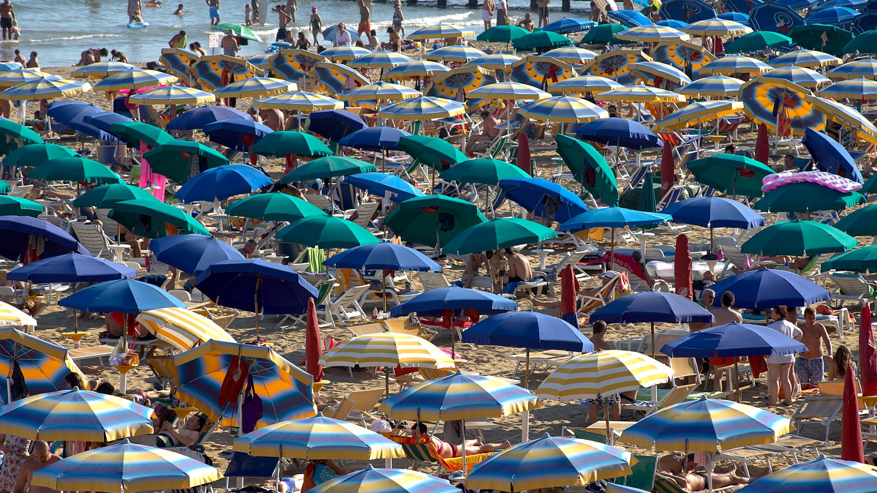 Playa atestada de gente en el litoral mediterráneo.