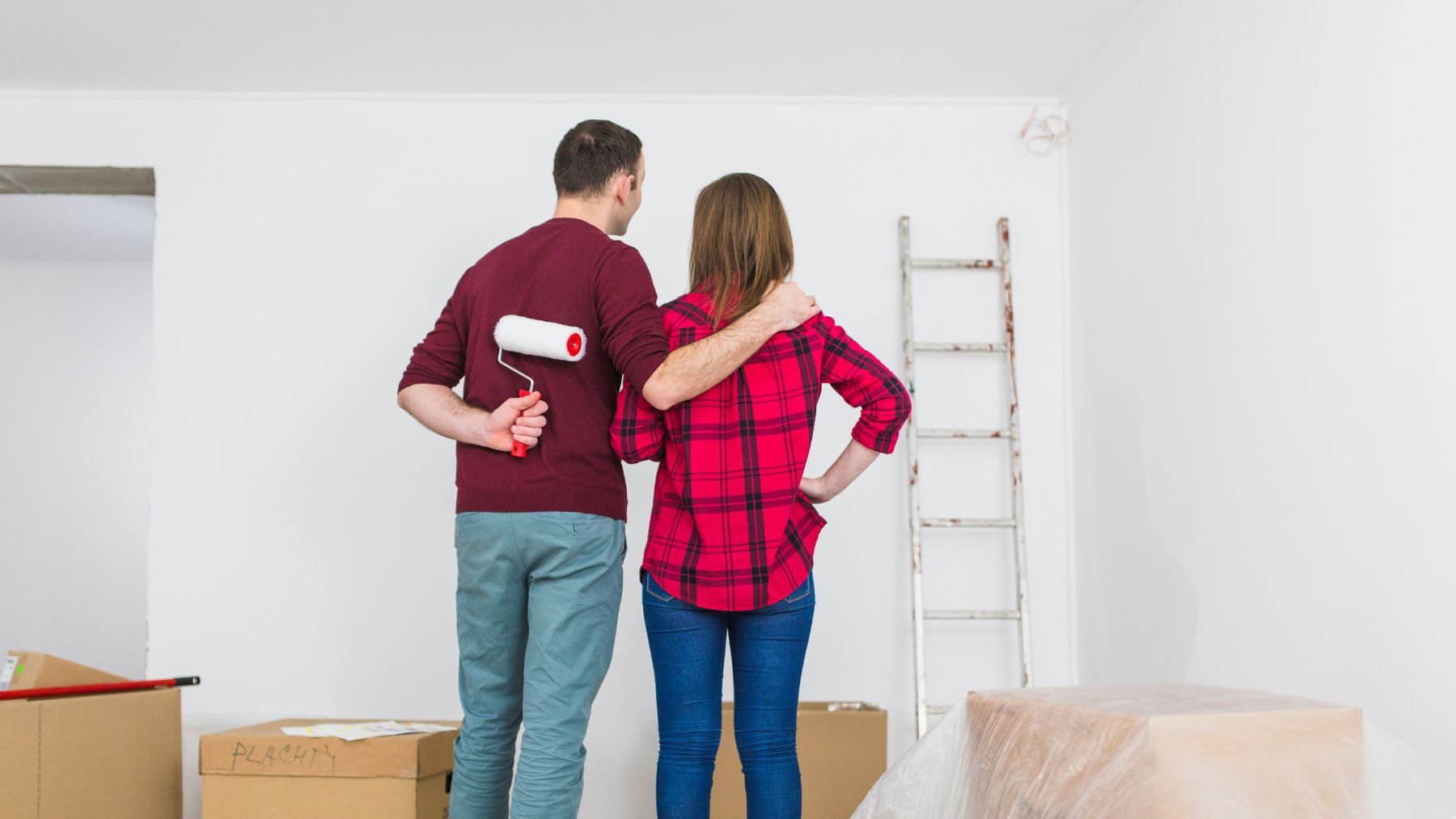 Una pareja mirando las paredes de su casa. Foto: Freepik