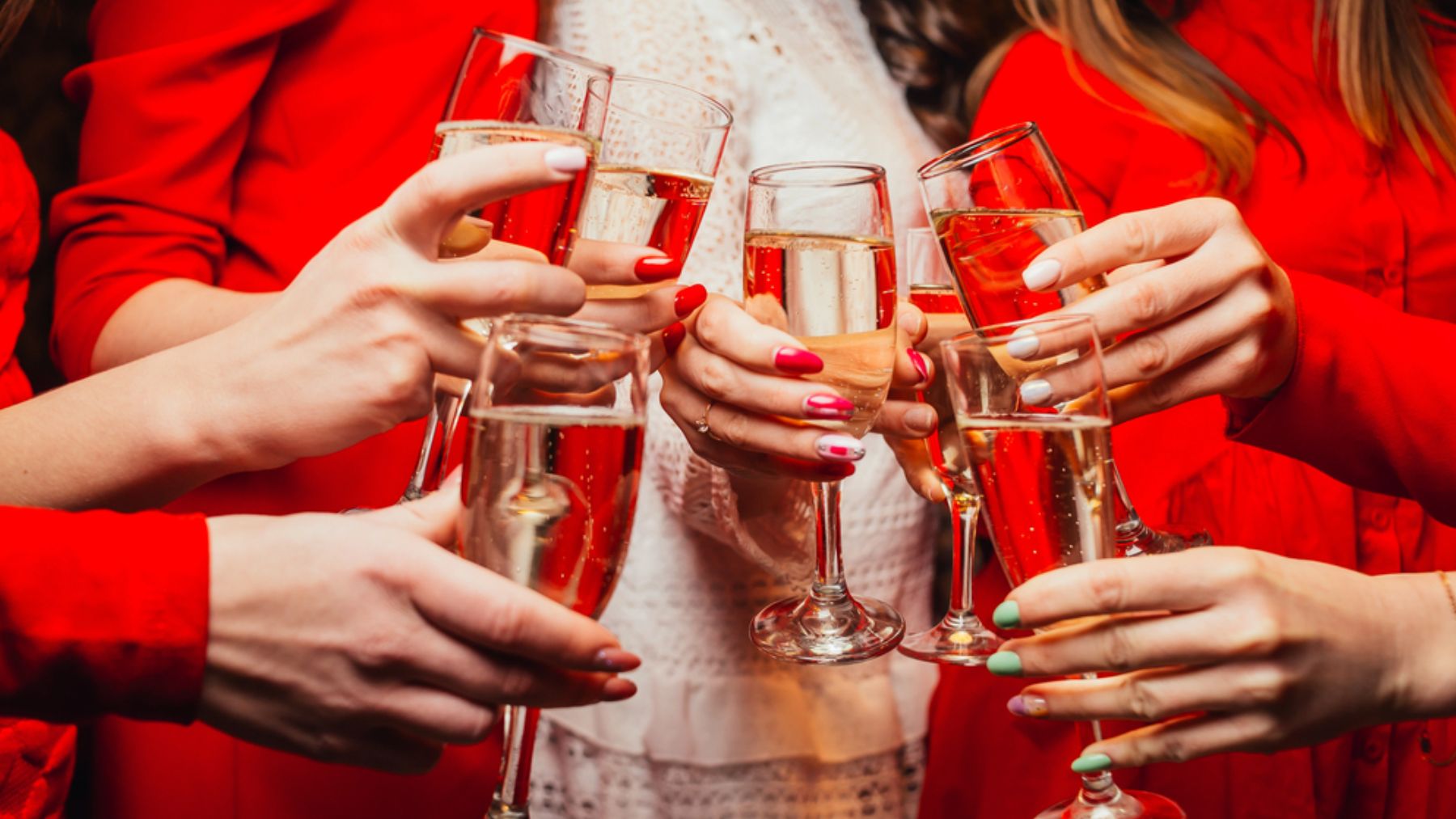 Un grupo de mujeres brindan con una copa de alcohol.