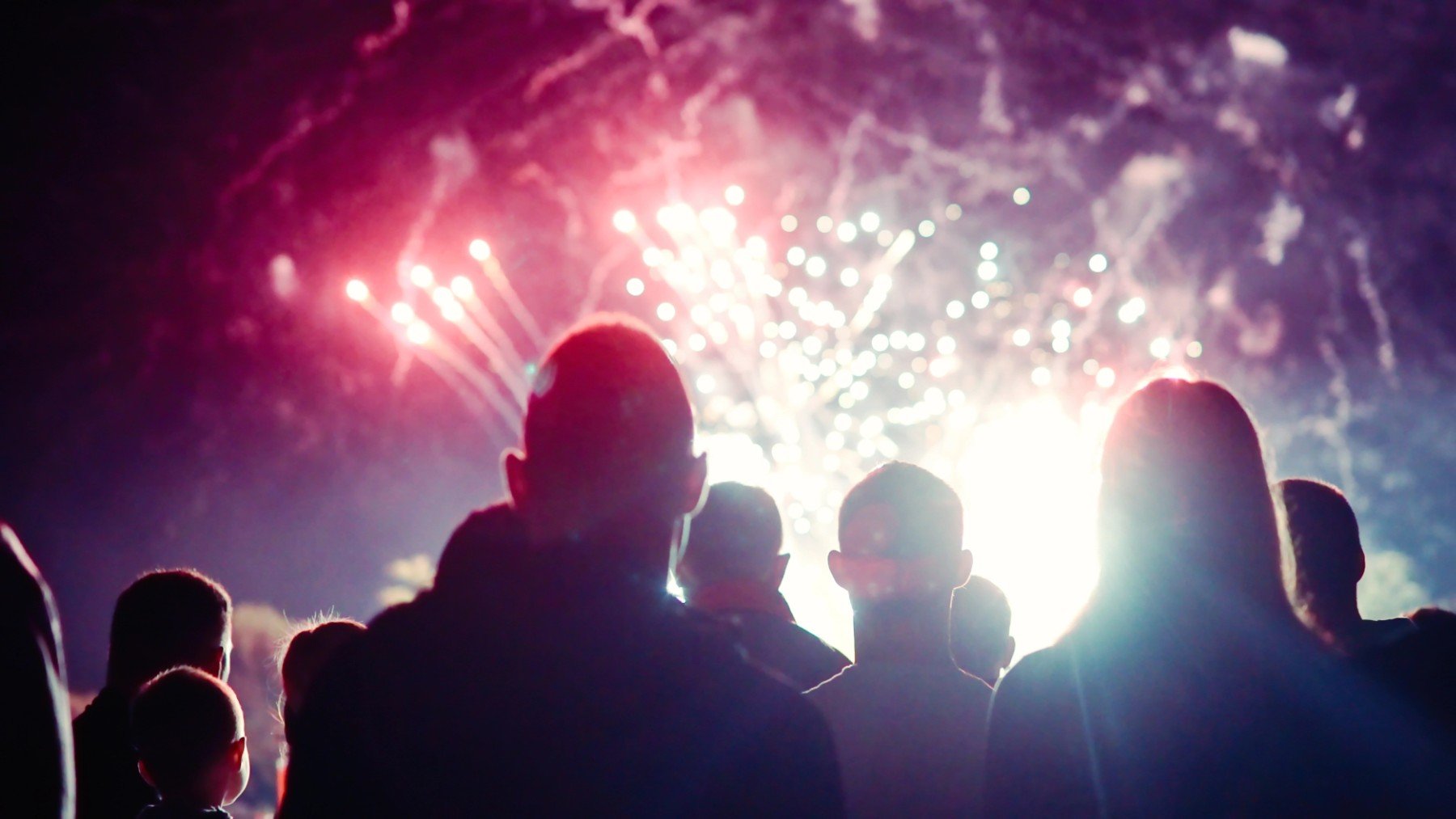 Varias personas viendo fuegos artificiales.