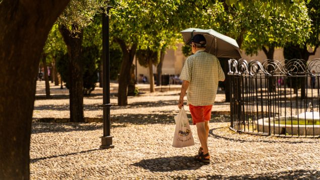 Un hombre se resguarda del sol de Córdoba con un paraguas. (Foto: Guillermo Morales)