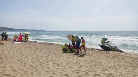 Socorristas atendiendo a dos personas con signos de ahogamiento en una playa de Fuengirola.