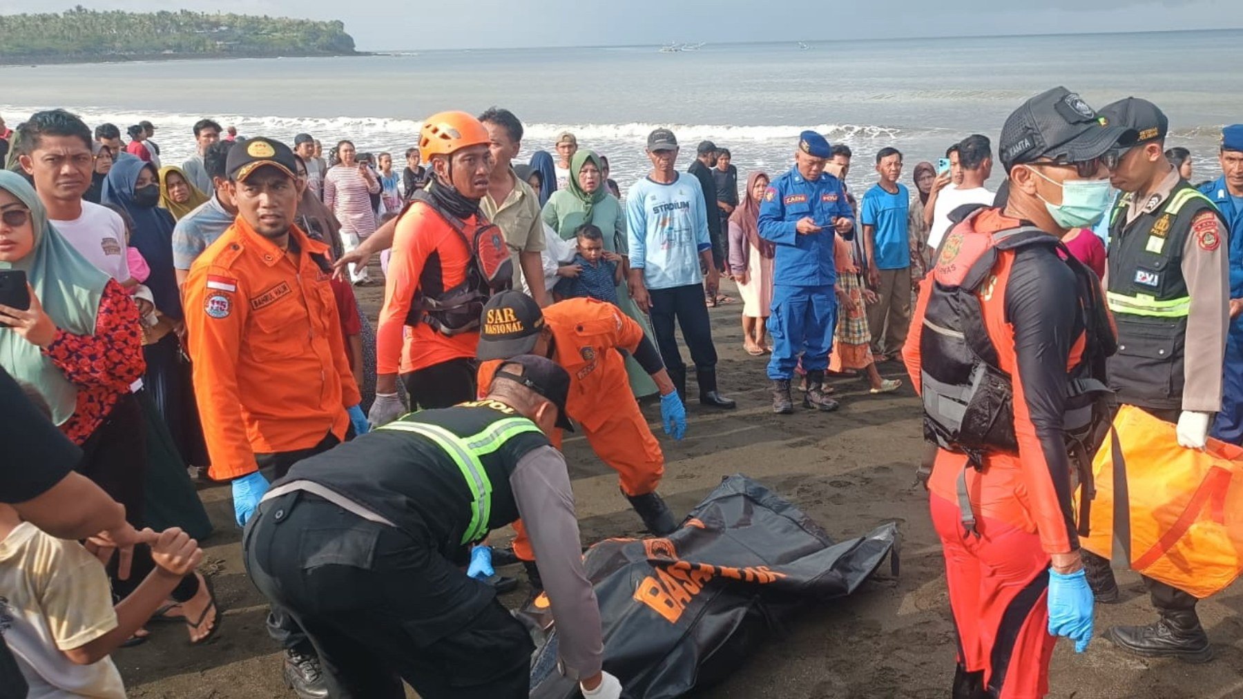 Autoridades indonesias con el cuerpo de una víctima del naufragio. (EFE)