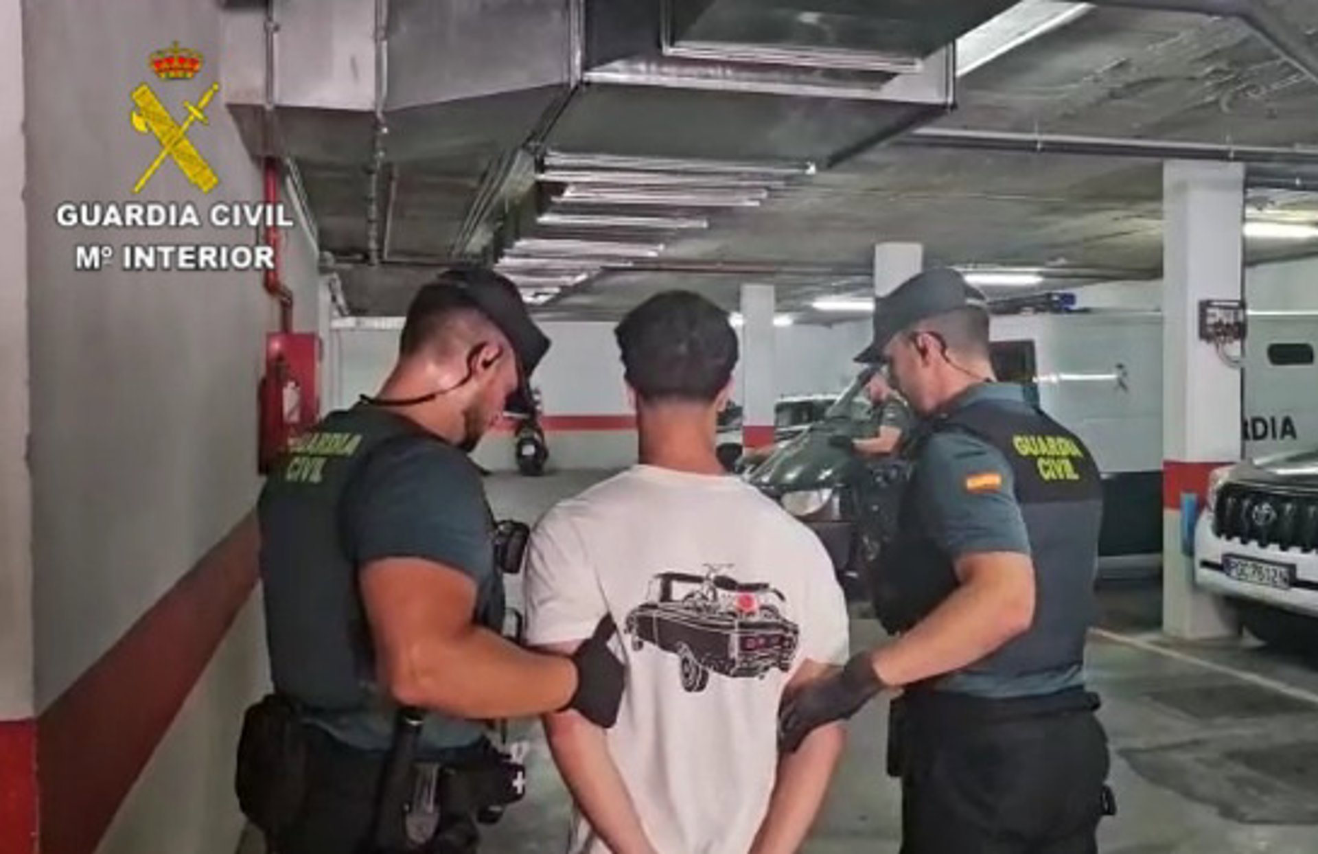Dos agentes de la Guardia Civil trasladan al detenido.