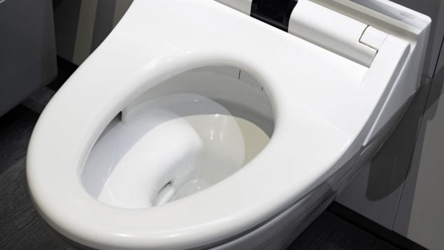 Cubrir el asiento en un baño público