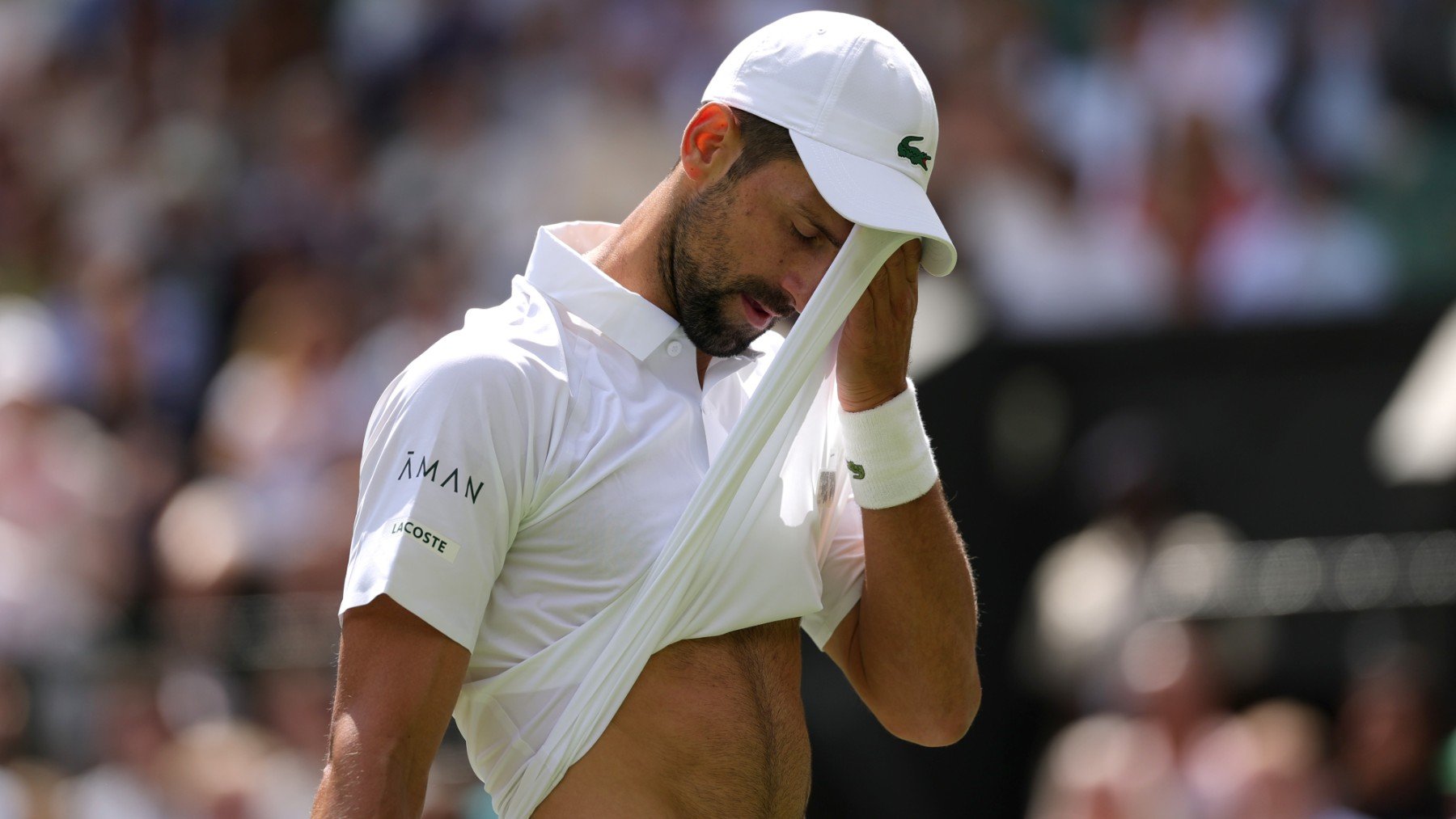Djokovic se frota la frente con su camiseta durante el partido contra De Miñaur. (Getty)