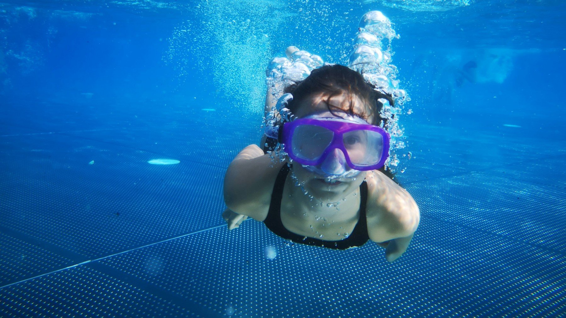 Un niño buceando con gafas.