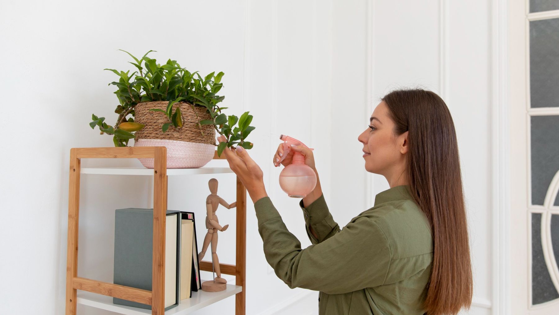 Una mujer regando su planta. Foto: Freepik