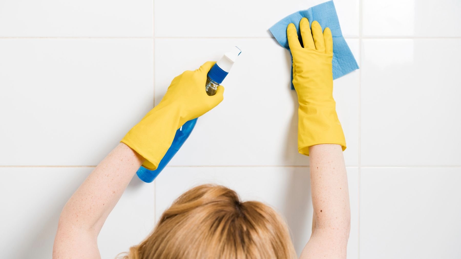 Una persona limpiando los azulejos. Foto: Freepik