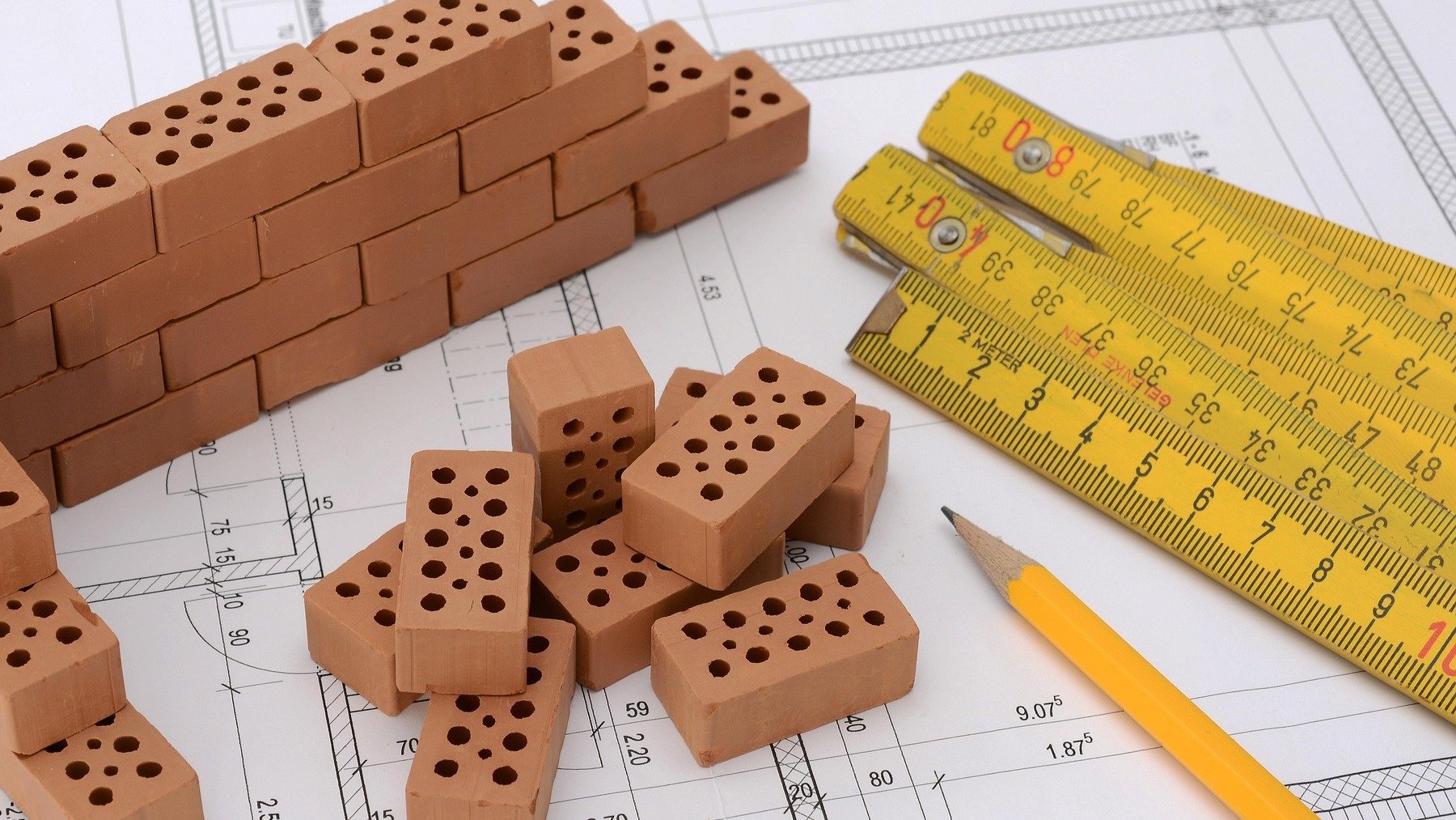 Ladrillos y plano de una casa.
