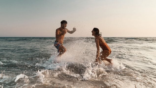 Dos personas disfrutan de la playa, paddle surf