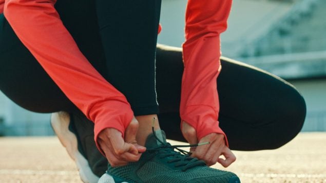 Una mujer se ata las zapatillas.