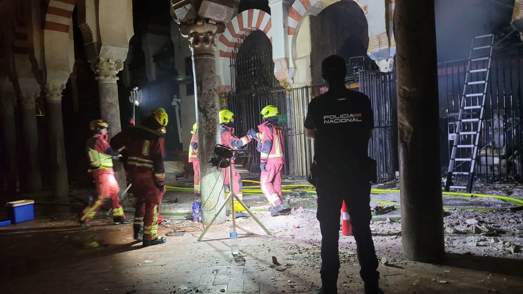 Bomberos en el interior de la Mezquita-Catedral de Córdoba tras el incendio. (EFE/Policía Nacional)