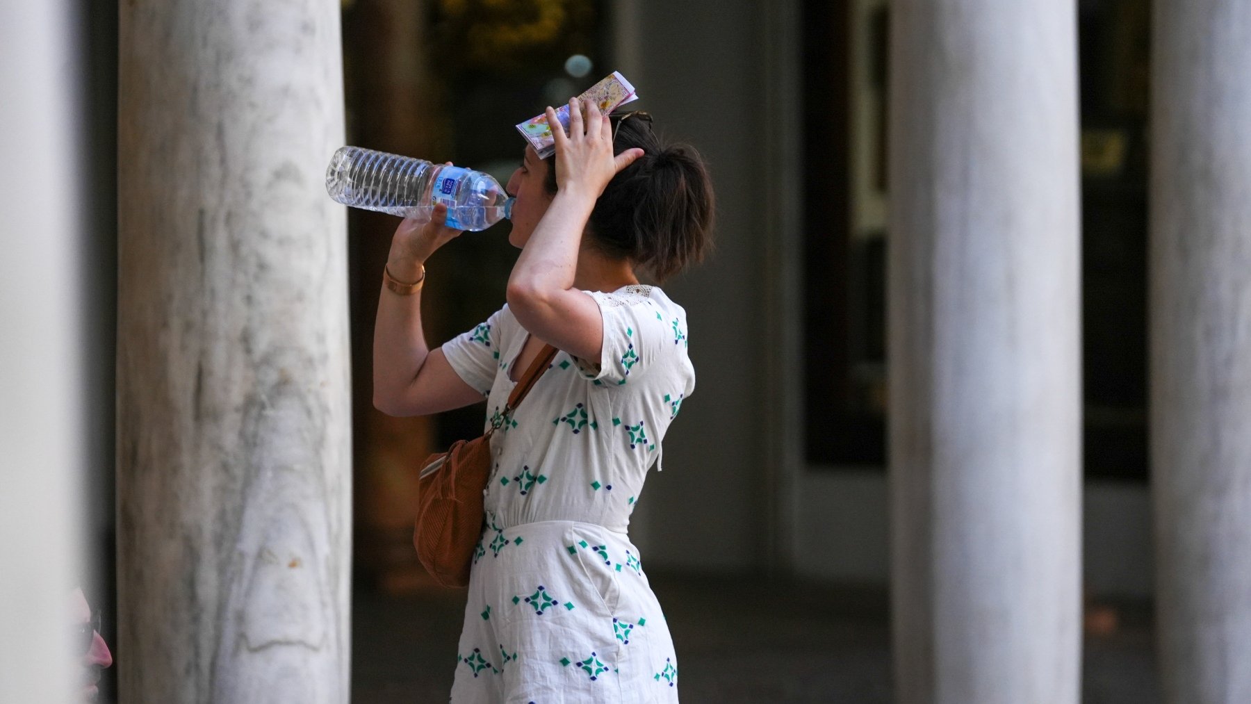 Una mujer bebe agua en Sevilla para combatir el calor. (Europa Press)