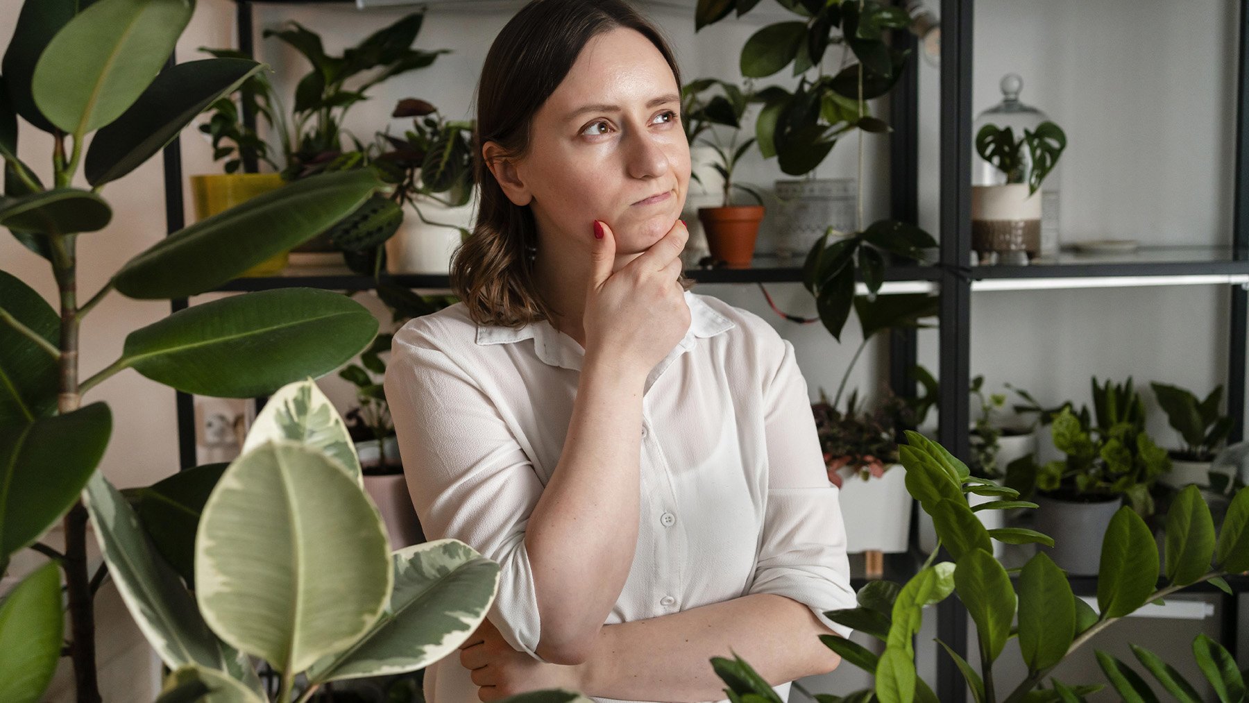 Una mujer pensando qué hacer con sus plantas