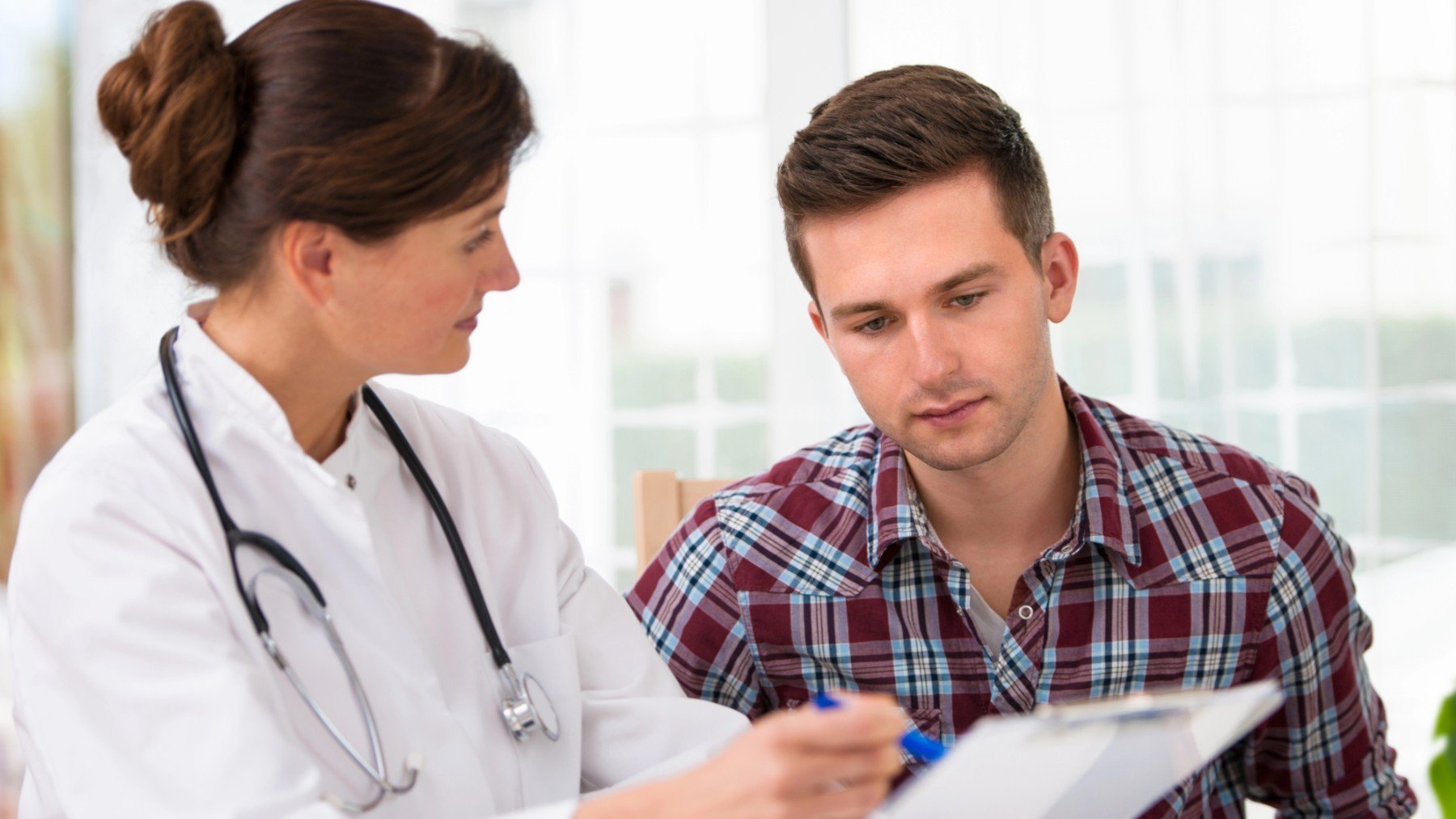 Una doctora conversa con un joven paciente.
