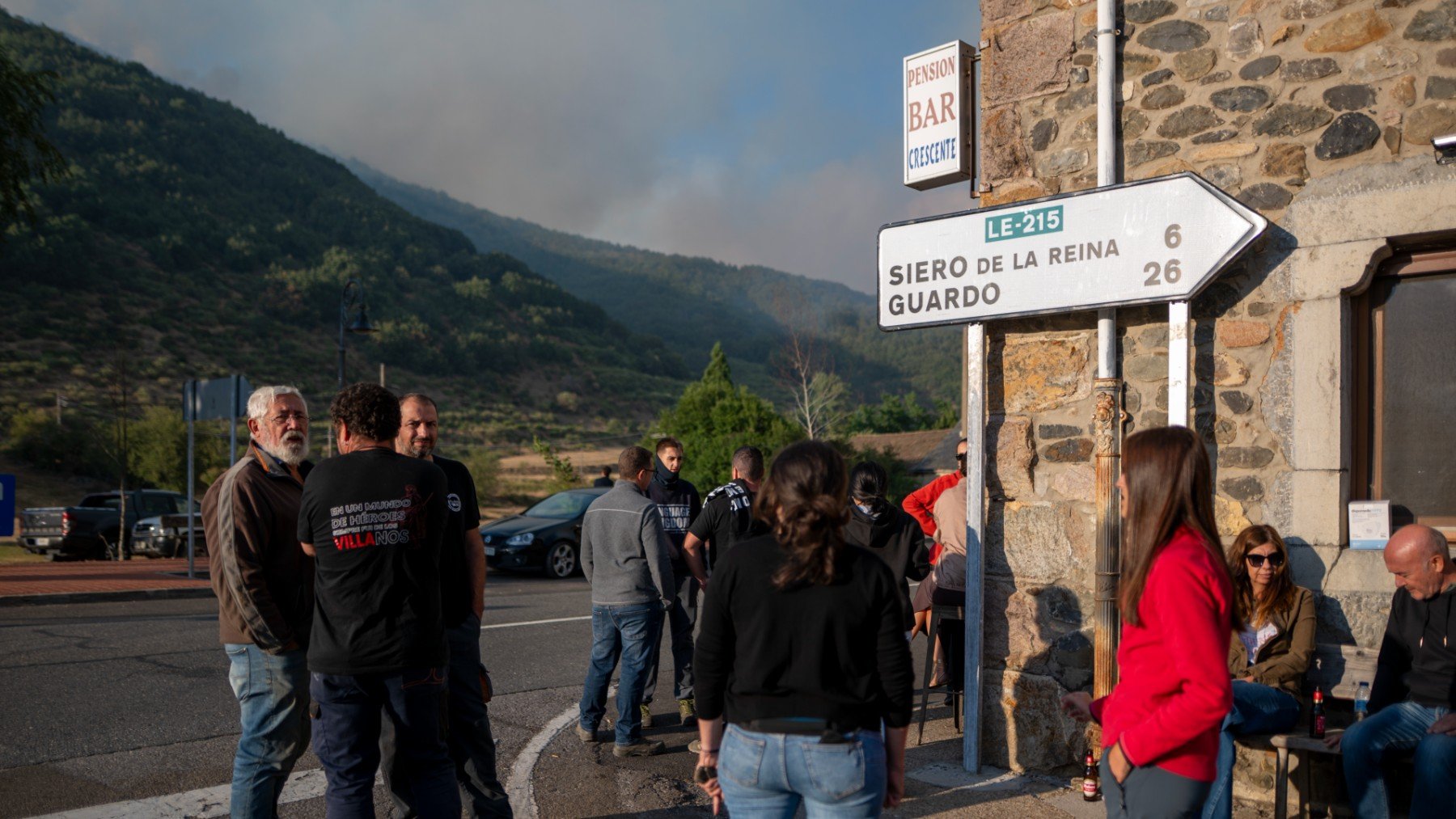 Varias personas observan el incendio en Boca de Huérgano, León.