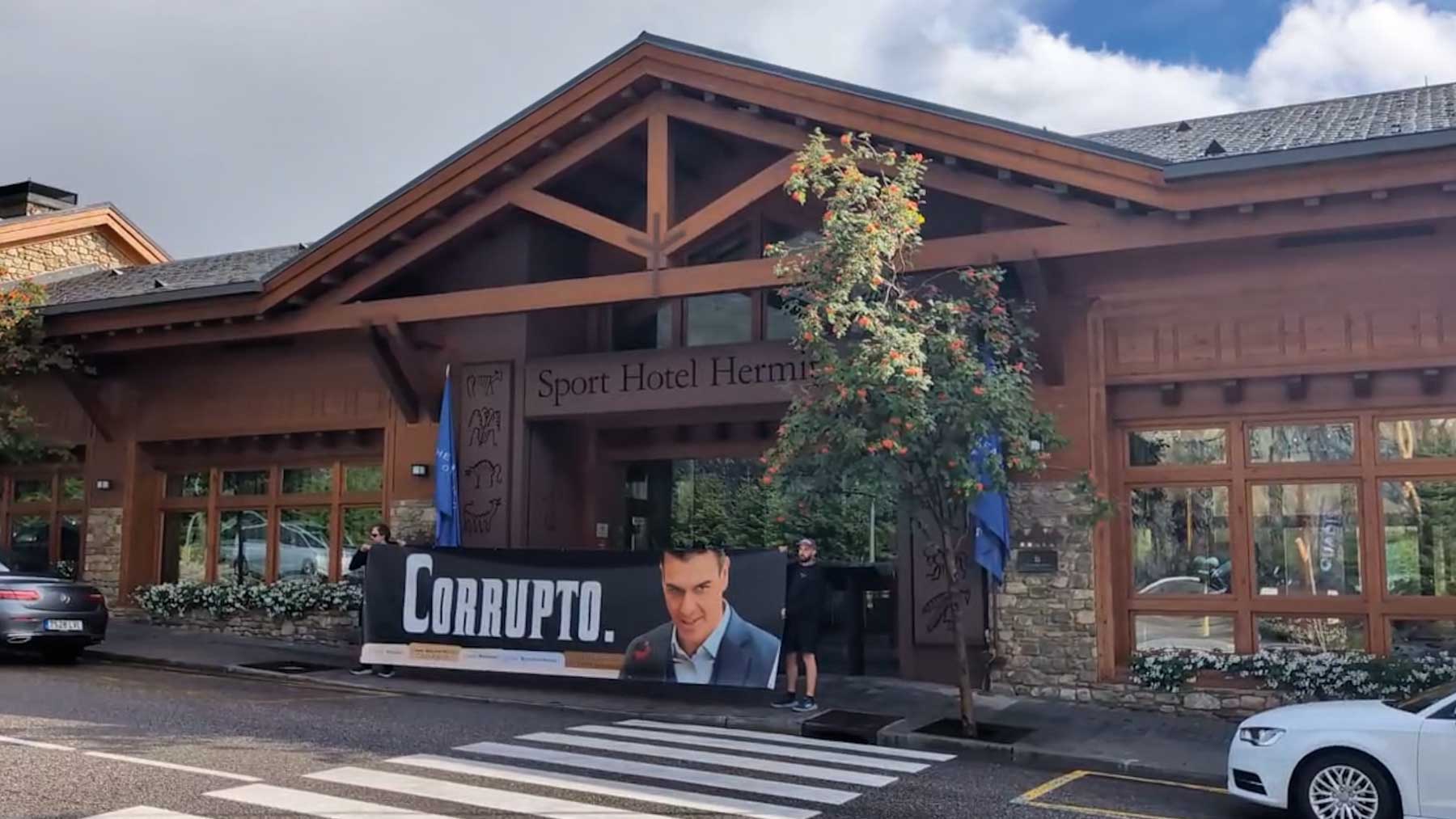 HazteOír coloca una lona de «Sánchez corrupto» en la puerta del hotel de lujo de sus vacaciones en Andorra
