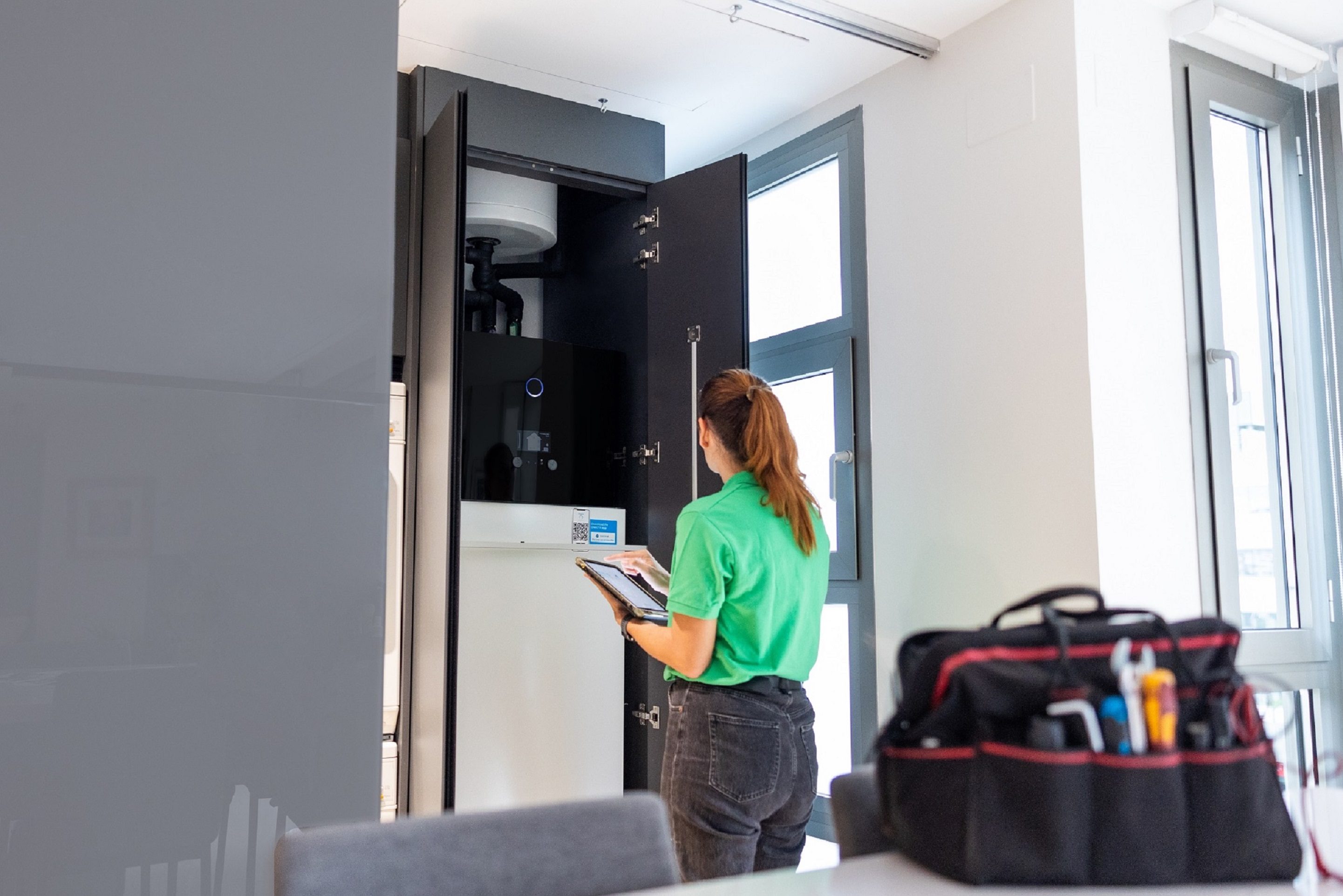 Técnico de Iberdrola ante la unidad interior de aerotermia en una vivienda