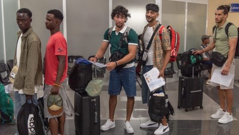 Inmigrantes del CETI hacen cola en el puerto de Ceuta para su traslado a la península. (Europa Press)