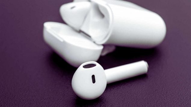 Auriculares Bluetooth sobre mesa, salud auditiva y efectos en el cerebro