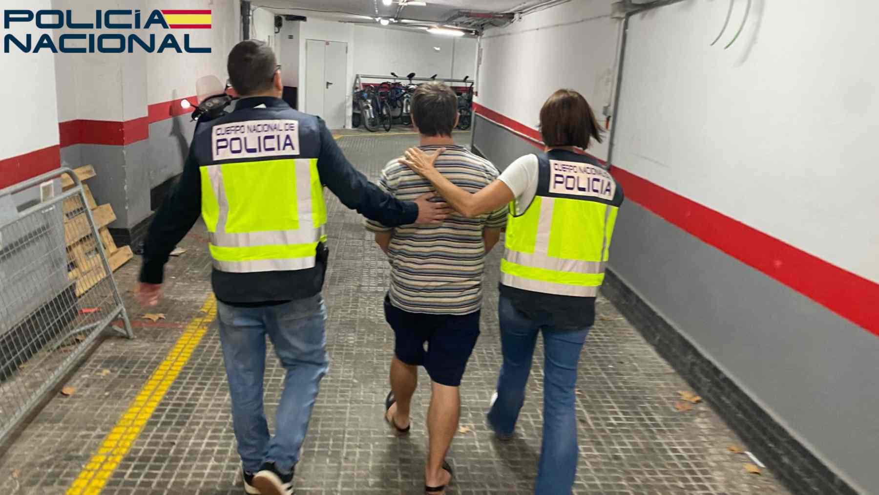El detenido, conducido por dos agentes de la Policía Nacional.