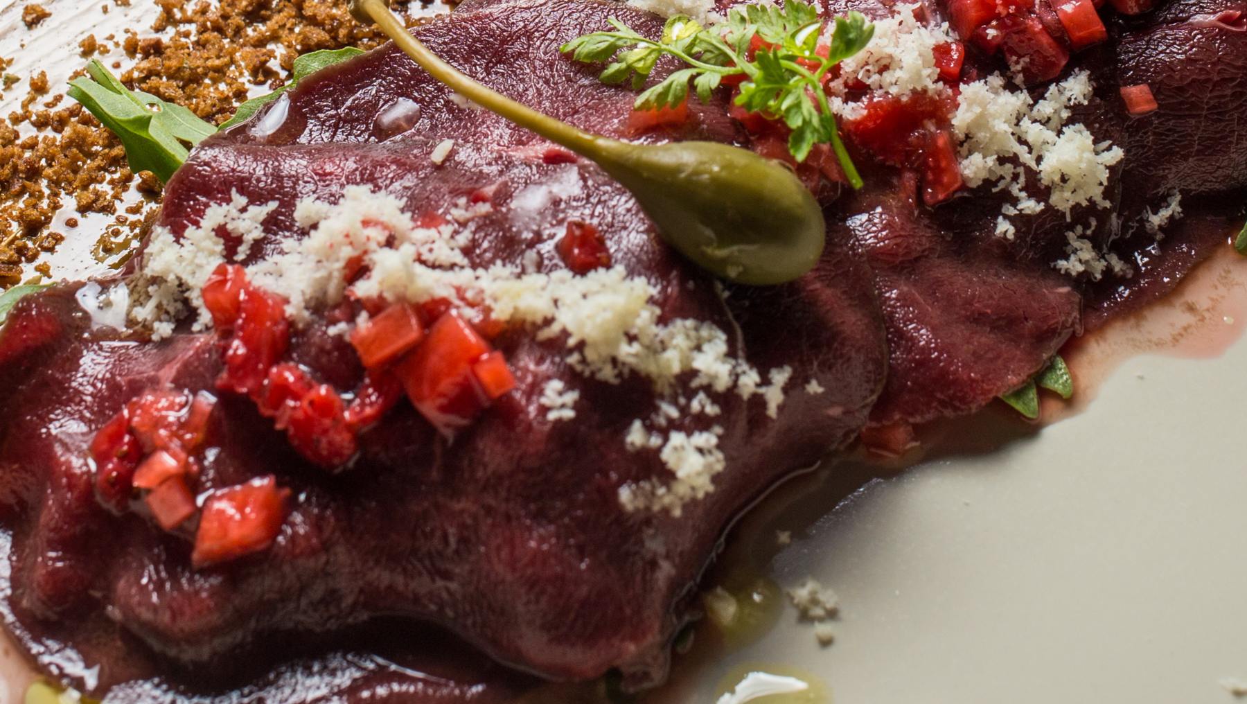 Carpaccio de ciervo con reducción de vino tinto y hierbas frescas