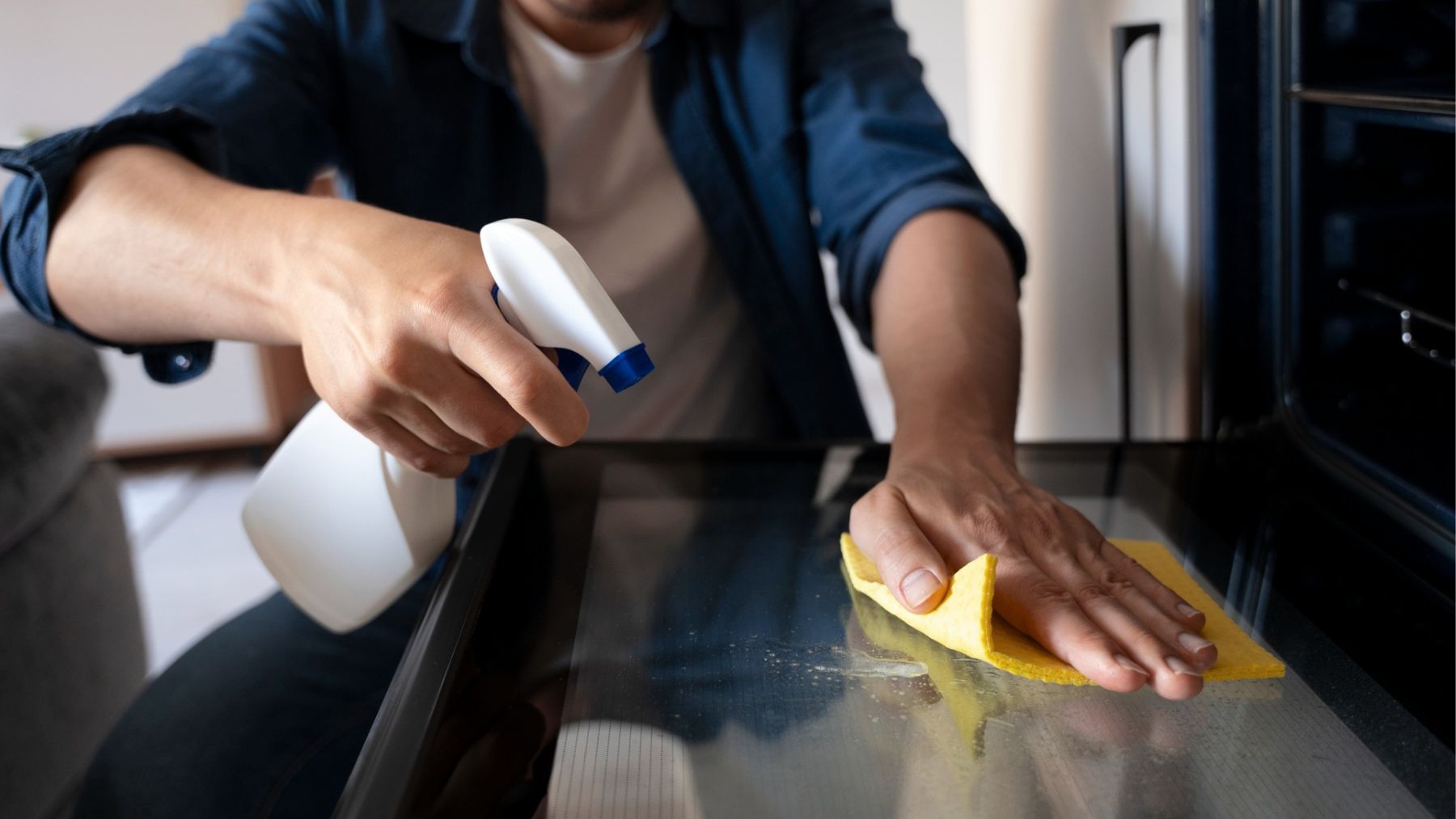 Una persona limpiando la puerta del horno. Foto: Freepik