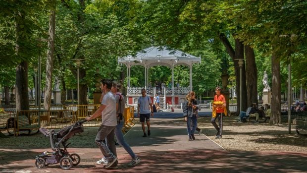 Gente paseando por una de las muchas zonas verdes de Vitoria-Gasteiz para protegerse del calor.
