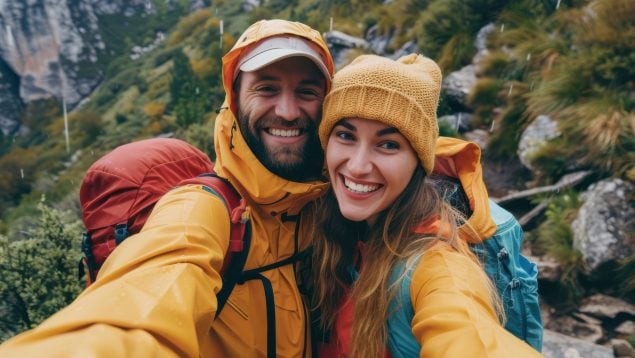 Dos senderistas en la montaña bajo la lluvia.