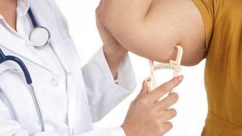 Un doctora mide la composición corporal de una paciente.