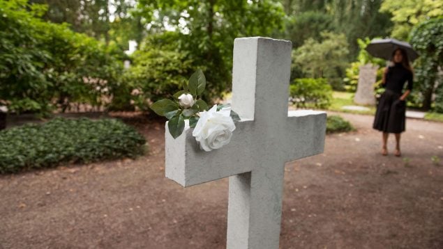 Cruz en un cementerio con viuda de fondo
