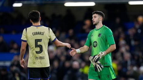 Joan García choca la mano a Cubarsí ante el Chelsea. (EP)