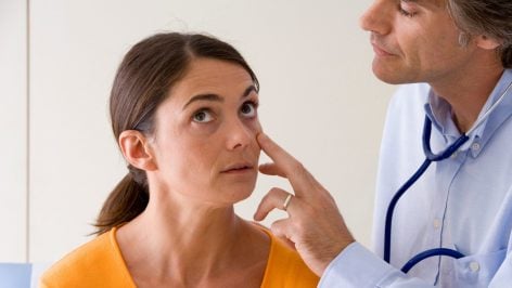 Un médico revisando los signos vitales de un paciente.