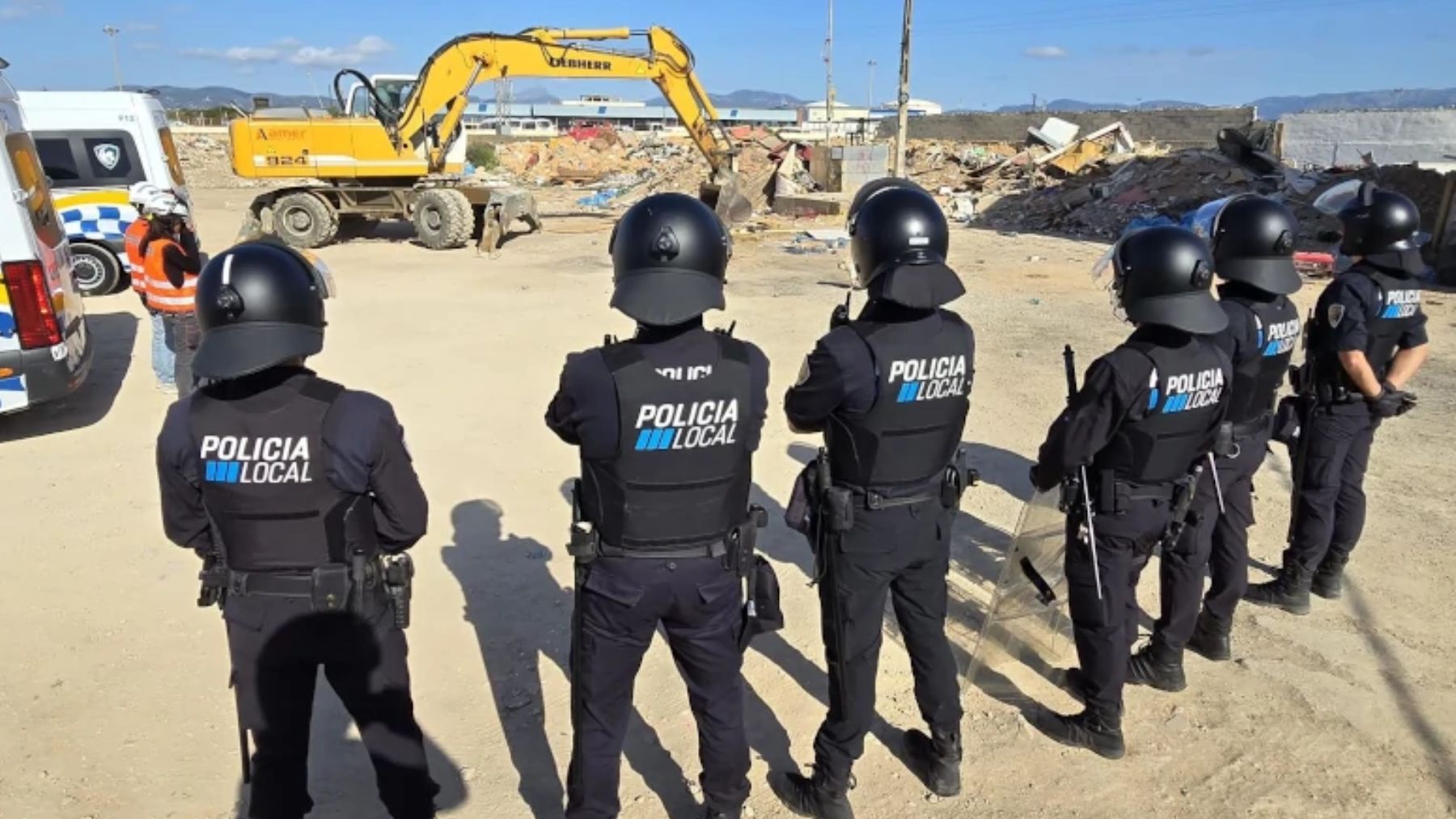 Agentes de la Policía Local de Palma dando cobertura a operarios municipales para derribar chabolas ilegales.