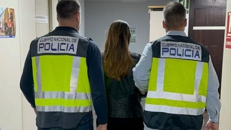 Dos agentes de la Policía Nacional conducen a la mujer detenida.