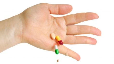 Una mano se desprende de varias pastillas.