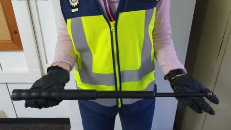 Una inspectora sujetando el bastón extensible incautado a uno de los agresores.
