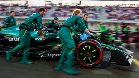 Los ingenieros de Aston Martin remolcan el coche de Fernando Alonso. (Getty)