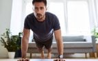 Un hombre hace deporte en casa.