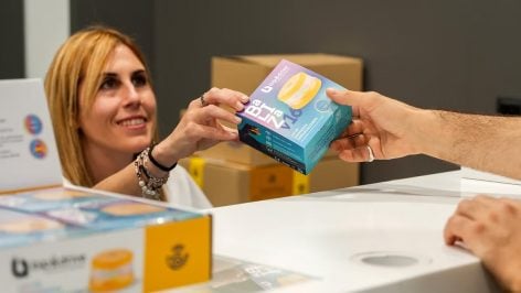 Empleada de correos entrega una baliza V16 a un cliente.