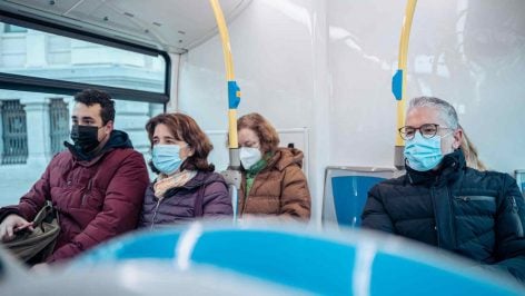 Varias personas con mascarilla en un autobús. E.P.