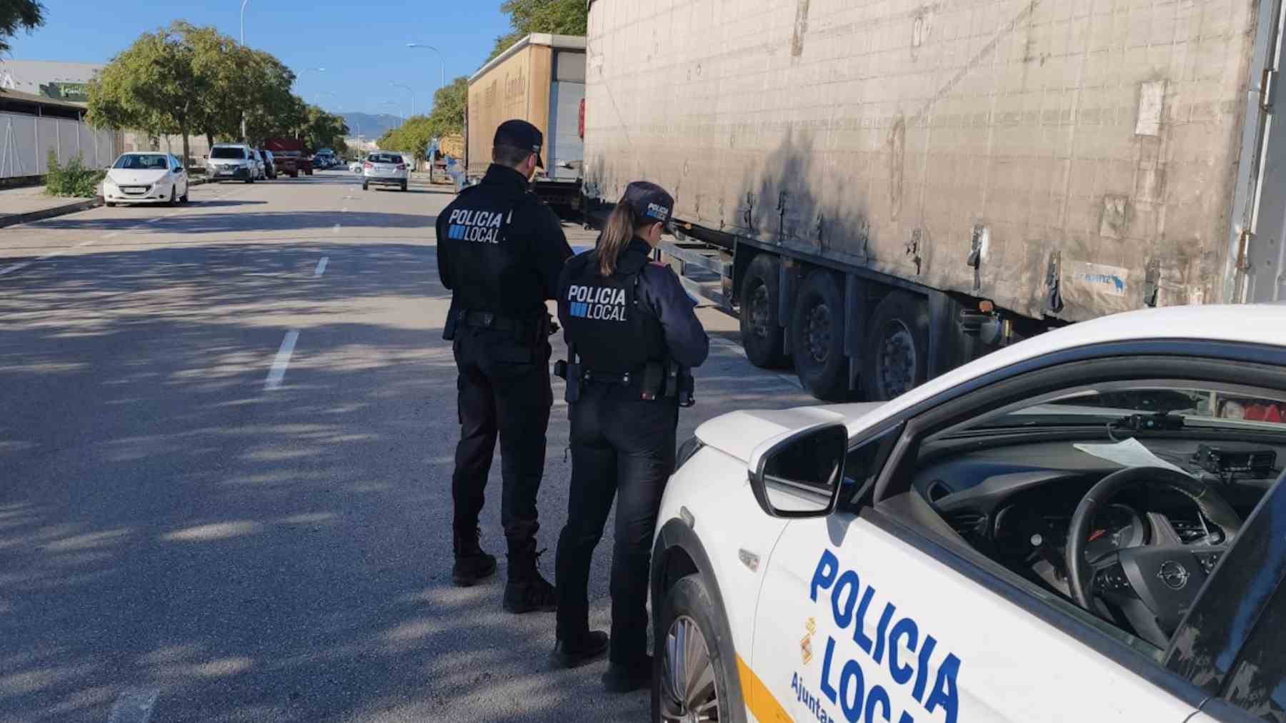 Dos agentes de la Policía Local de Palma sancionan uno de los remolques estacionados en Son Güells.