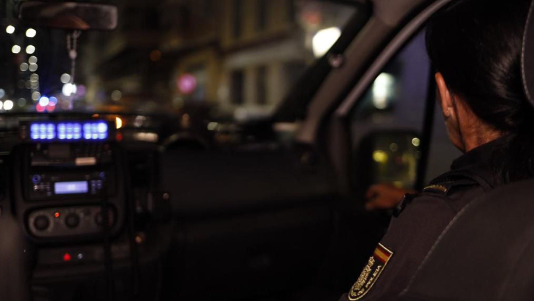 Interior de un coche patrulla realizando el traslado de un detenido.