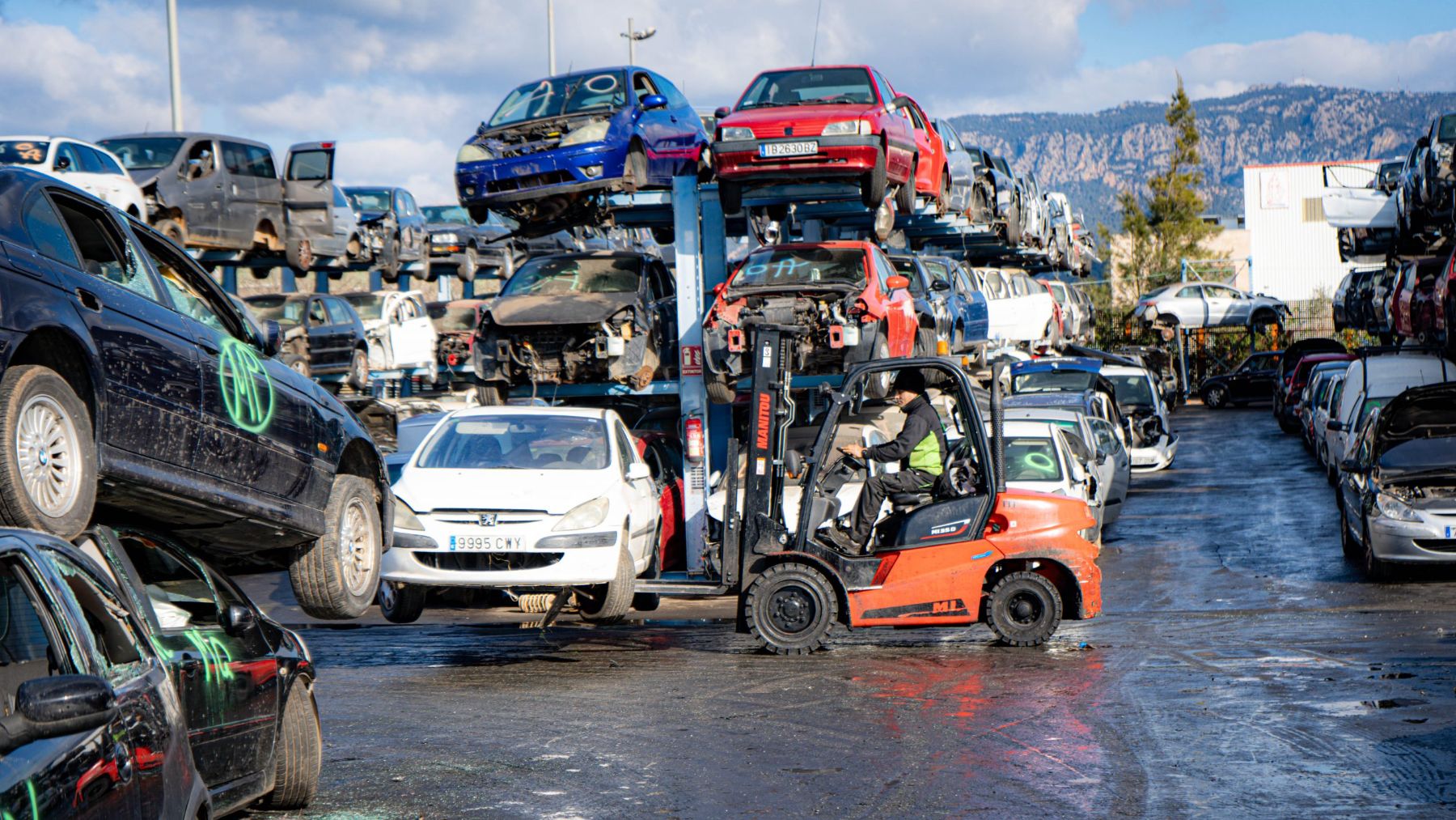 Imagen de un trabajador trasportando vehículos en Reciclajes Pérez.