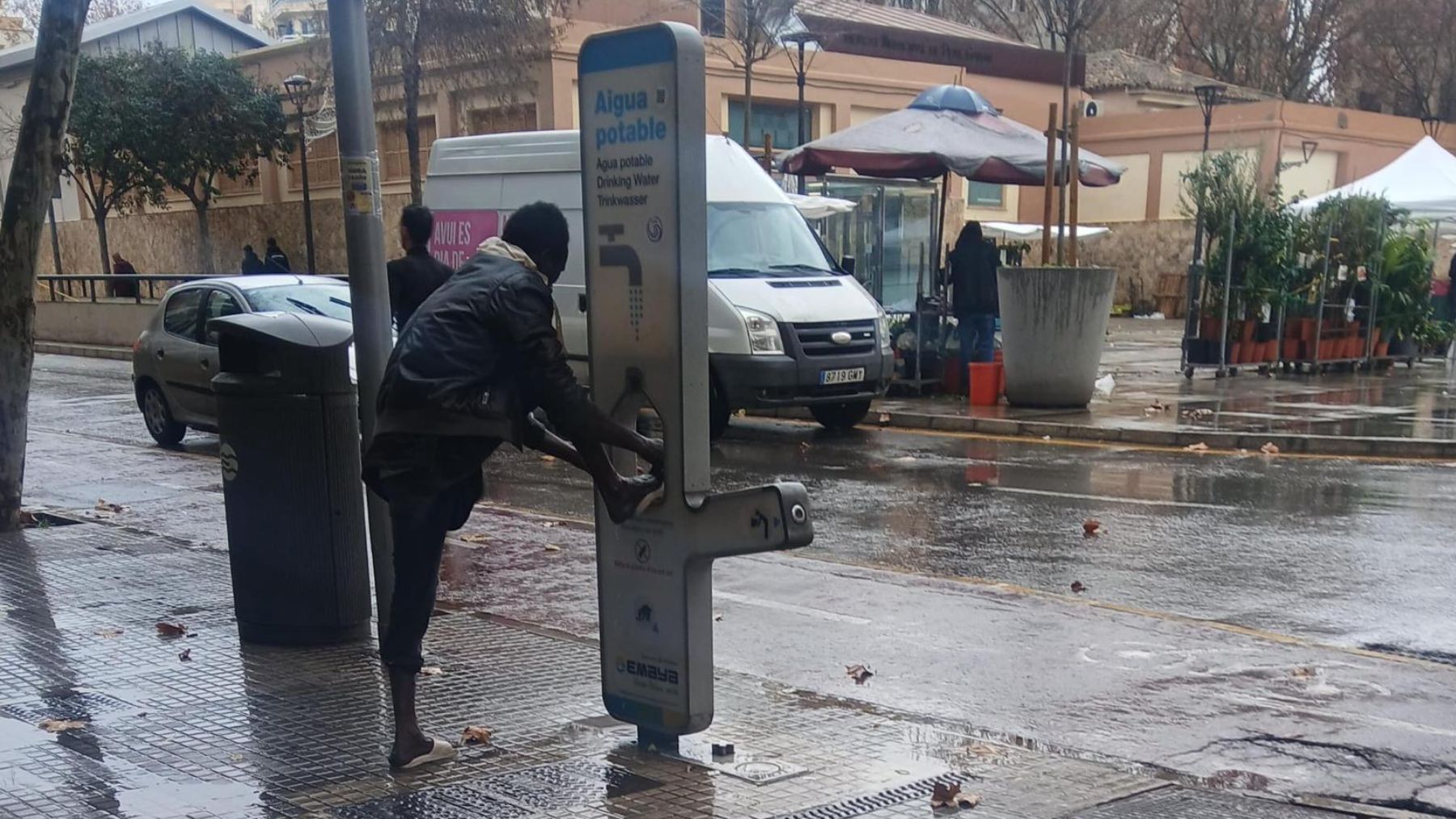 Inmigrantes se lavan los pies en las fuentes de agua de Palma que el Ayuntamiento instaló para beber